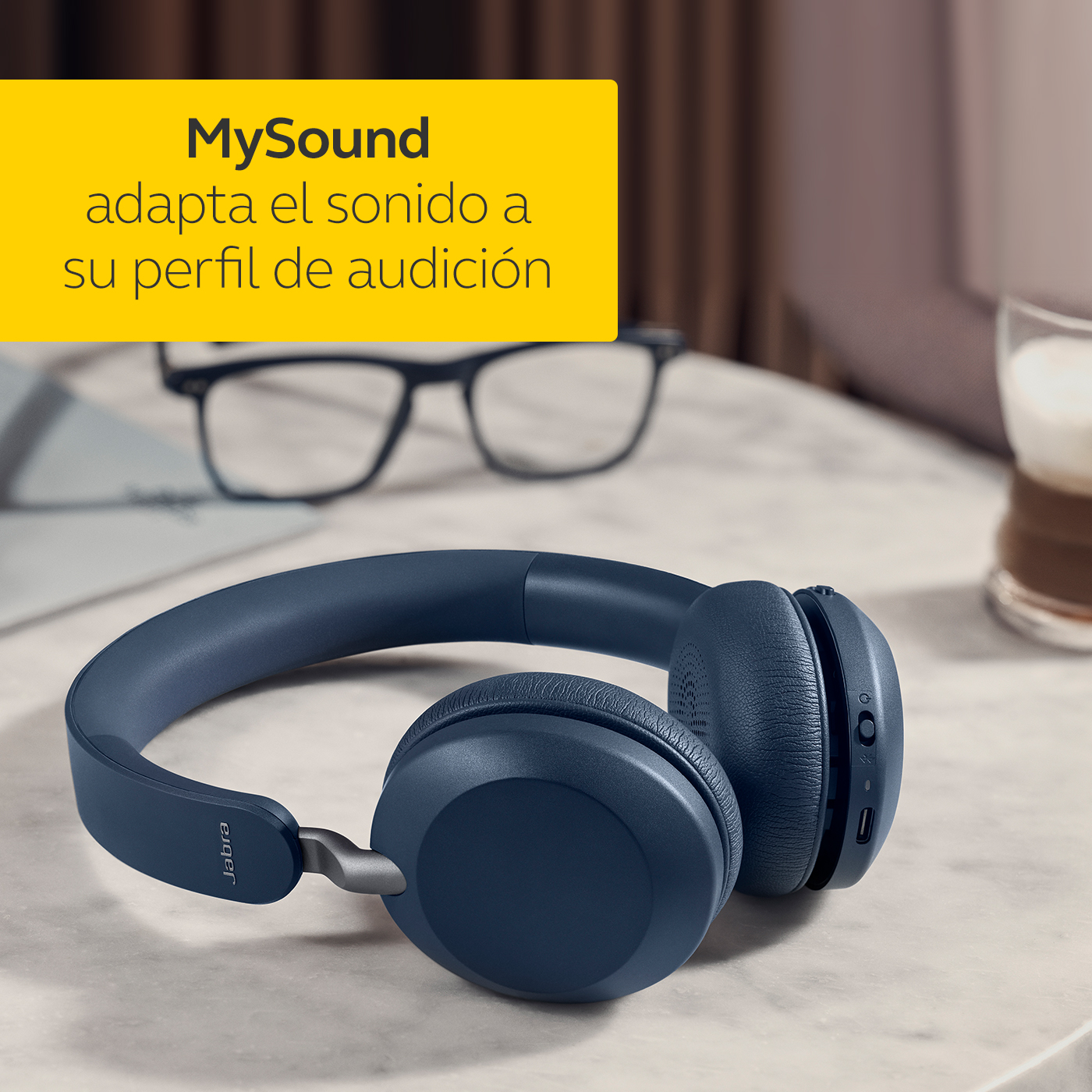 Auriculares Jabra azules sobre superficie de mármol, etiqueta amarilla en esquina superior.