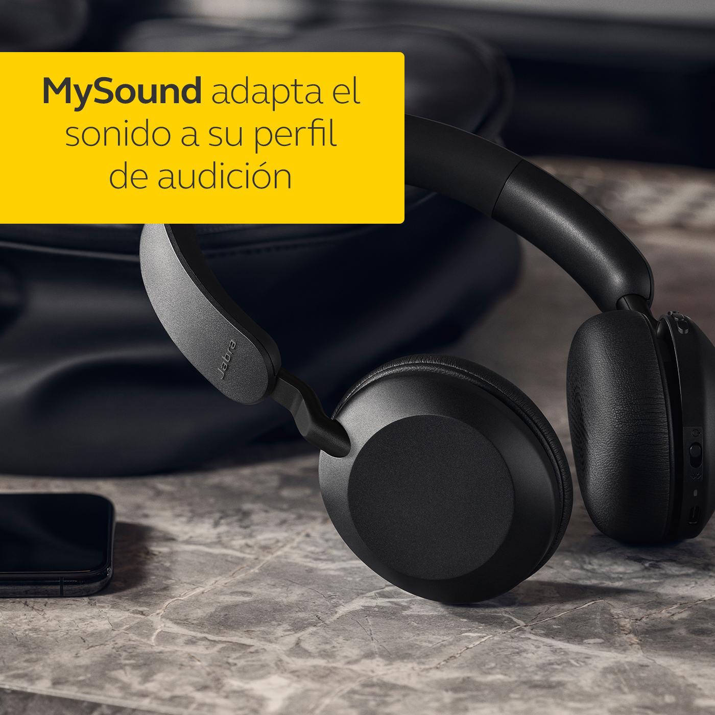 Auriculares negros sobre una superficie con un rectángulo amarillo que superpone texto en español: 'MySound adapta el sonido'.