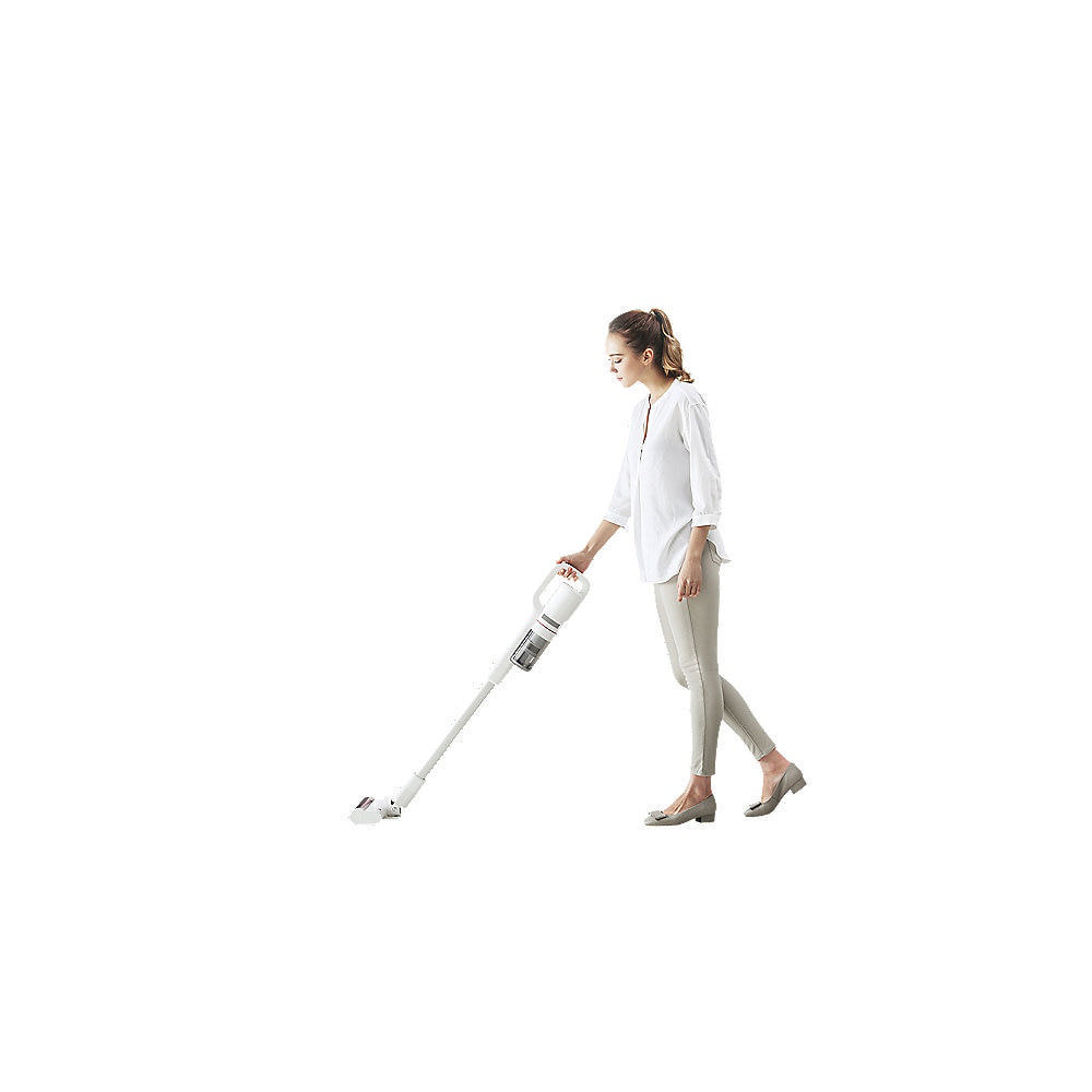 Eine Frau in weißem Hemd und grauer Hose benutzt einen weißen kabellosen Staubsauger auf weißem Boden.