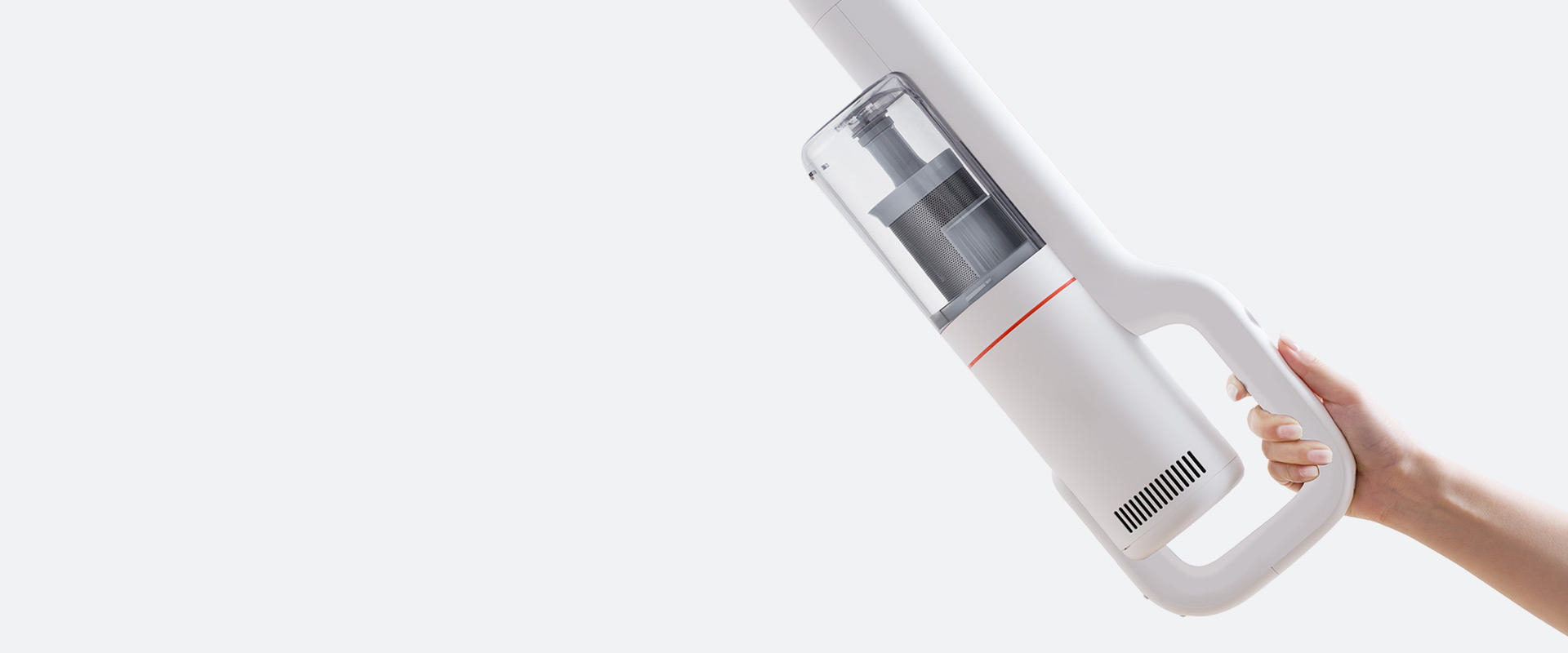 Ein weißer Staubsauger wird von einer Hand gehalten. Der Staubsauger ist aufrecht und hat einen Griff.