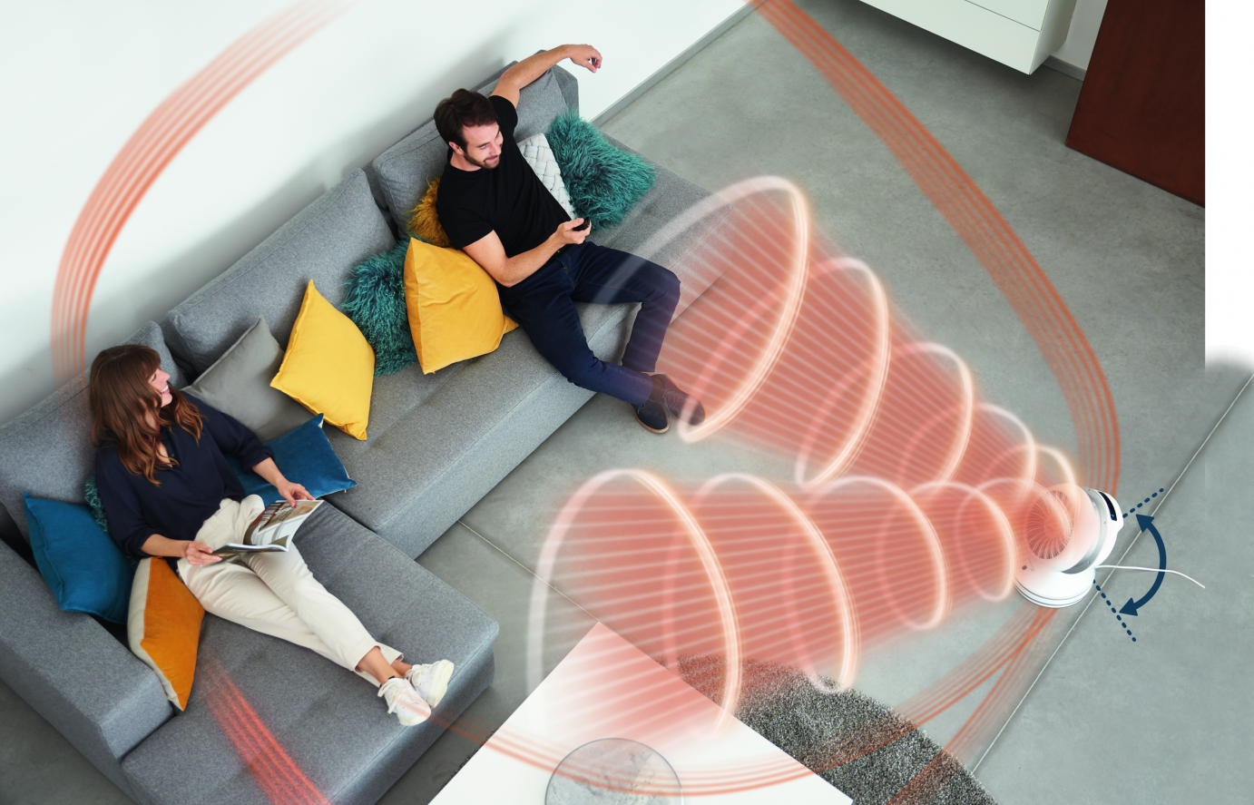 Un couple est assis sur un canapé tandis qu'un aspirateur robot nettoie le sol. Des trajectoires de nettoyage rouges sont visibles.