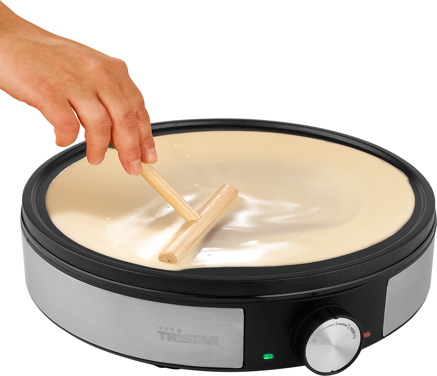 Person spreading batter on a pancake griddle with wooden tools.