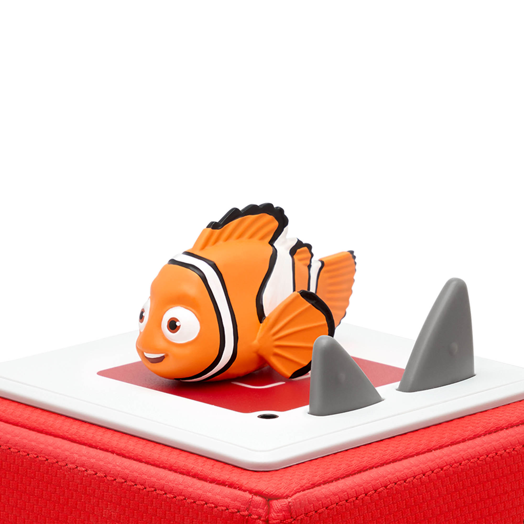 Nemo-Fischspielzeug auf einer roten Box mit Hai-Flossen-Spielzeugen.