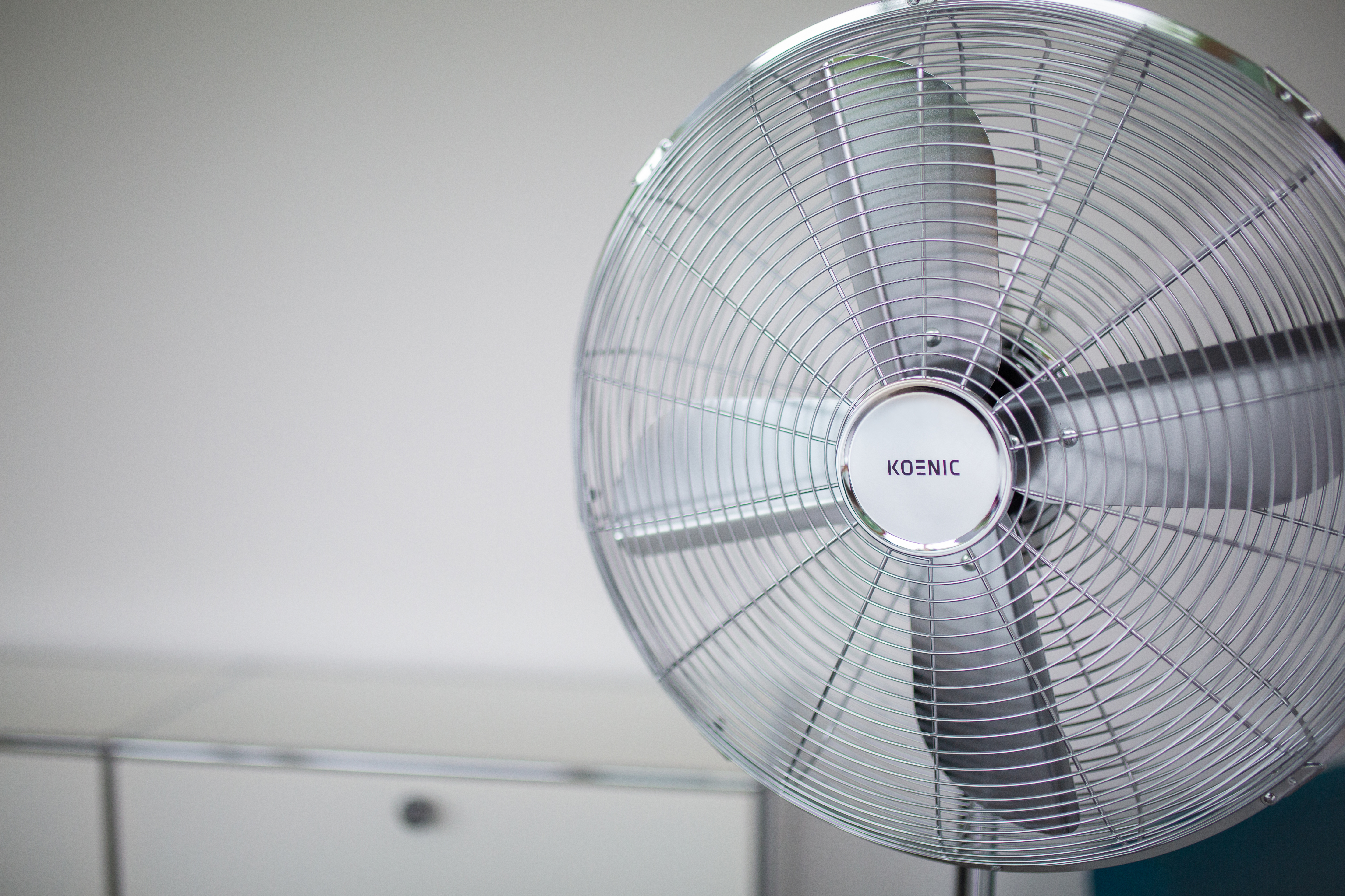 Un ventilatore argentato con il logo KOENIC al centro.