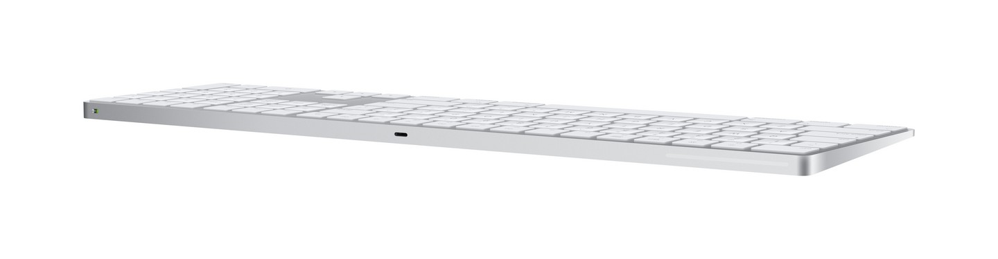 Teclado plateado, diseño delgado, con teclas blancas y puerto de carga lateral.
