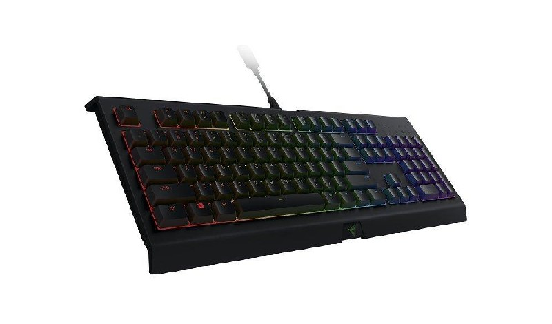 Un teclado de ordenador negro con teclas coloridas, en ángulo hacia arriba, con cable.