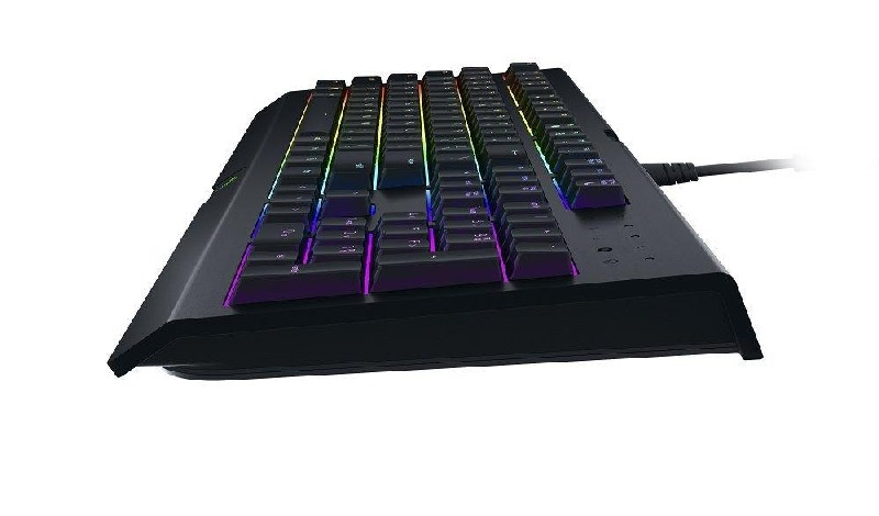 Teclado negro con teclas multicolores. Está en ángulo, mostrando la vista lateral.