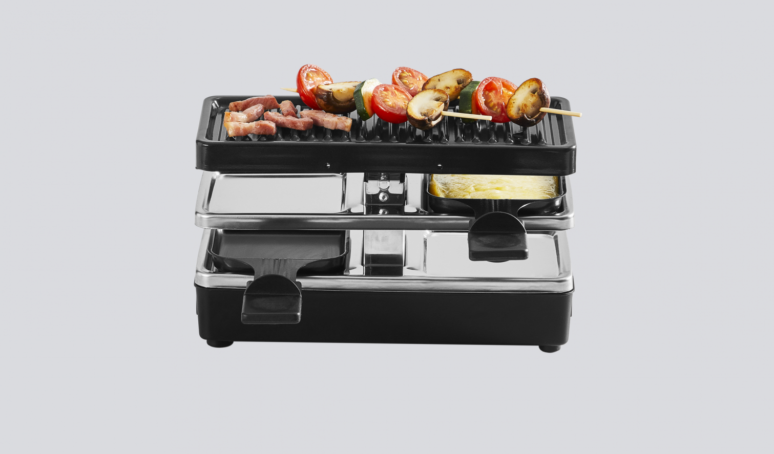 Un grill raclette avec de la nourriture: tomates, champignons et fromage.