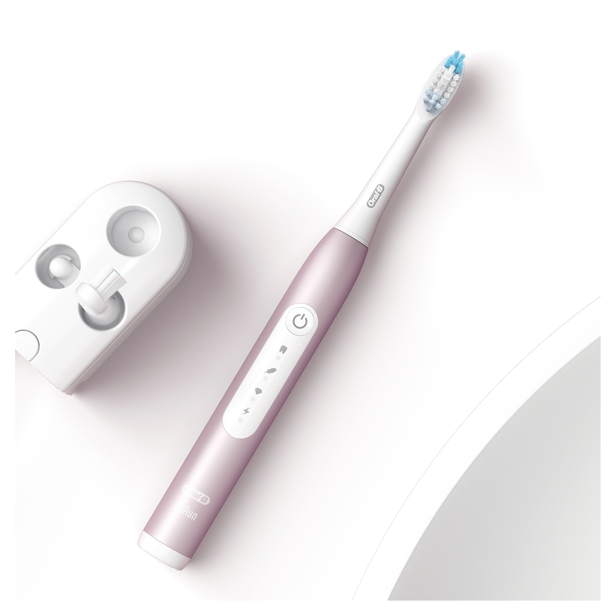 Eine elektrische Zahnbürste und ihre Ladestation auf weißer Oberfläche, mit pinkfarbenem Gehäuse.