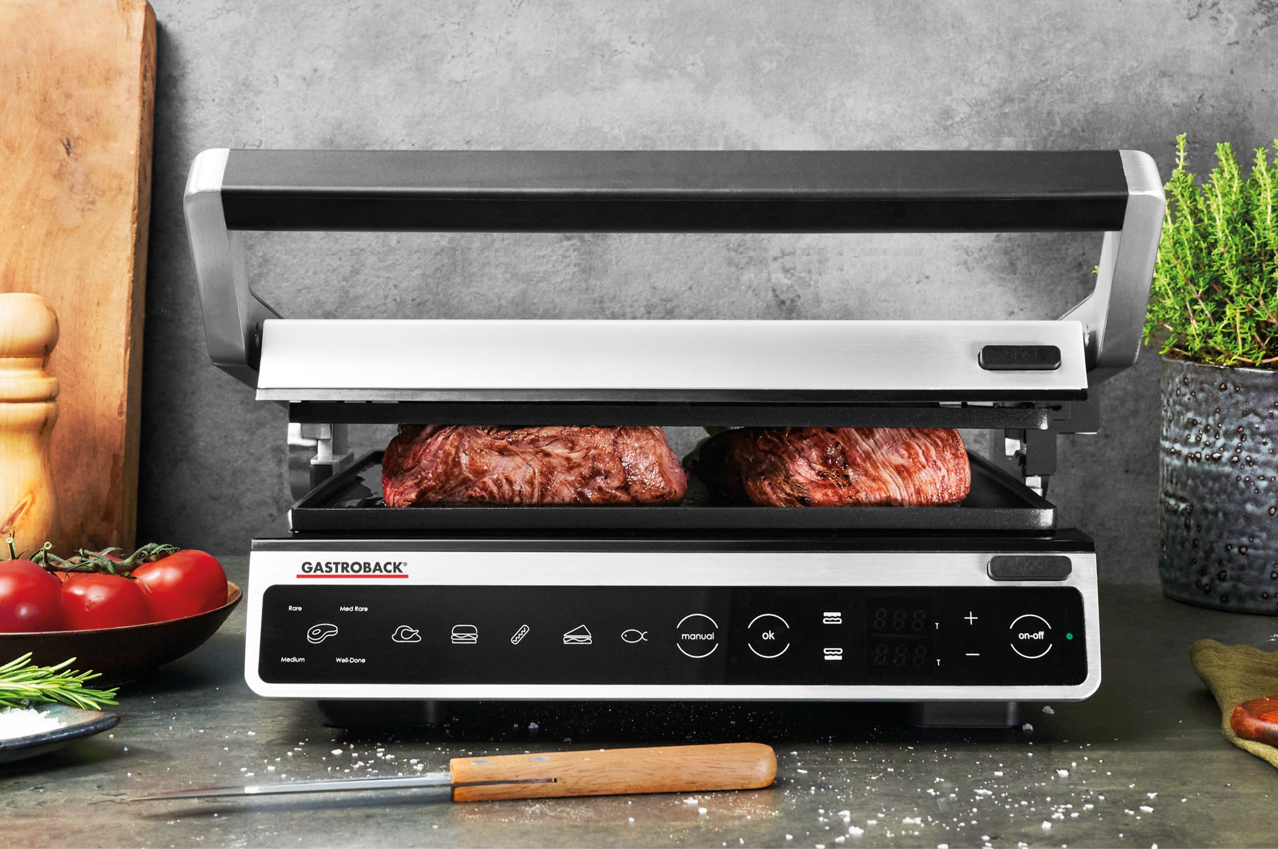 Grill mit Steaks, offen auf der Arbeitsplatte.