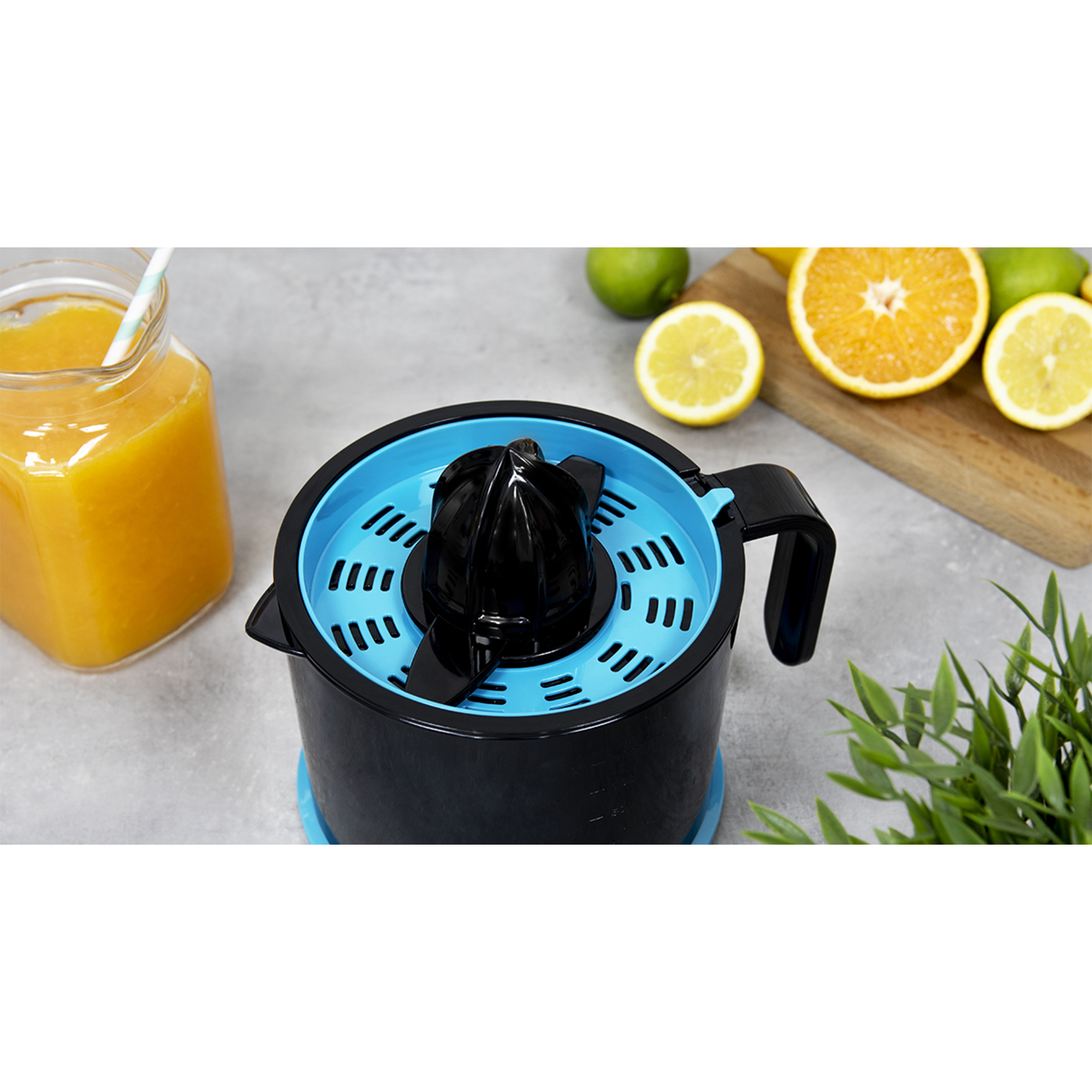 Exprimidor negro y azul con jugo y fruta. Un frasco lleno de jugo y algo de fruta.