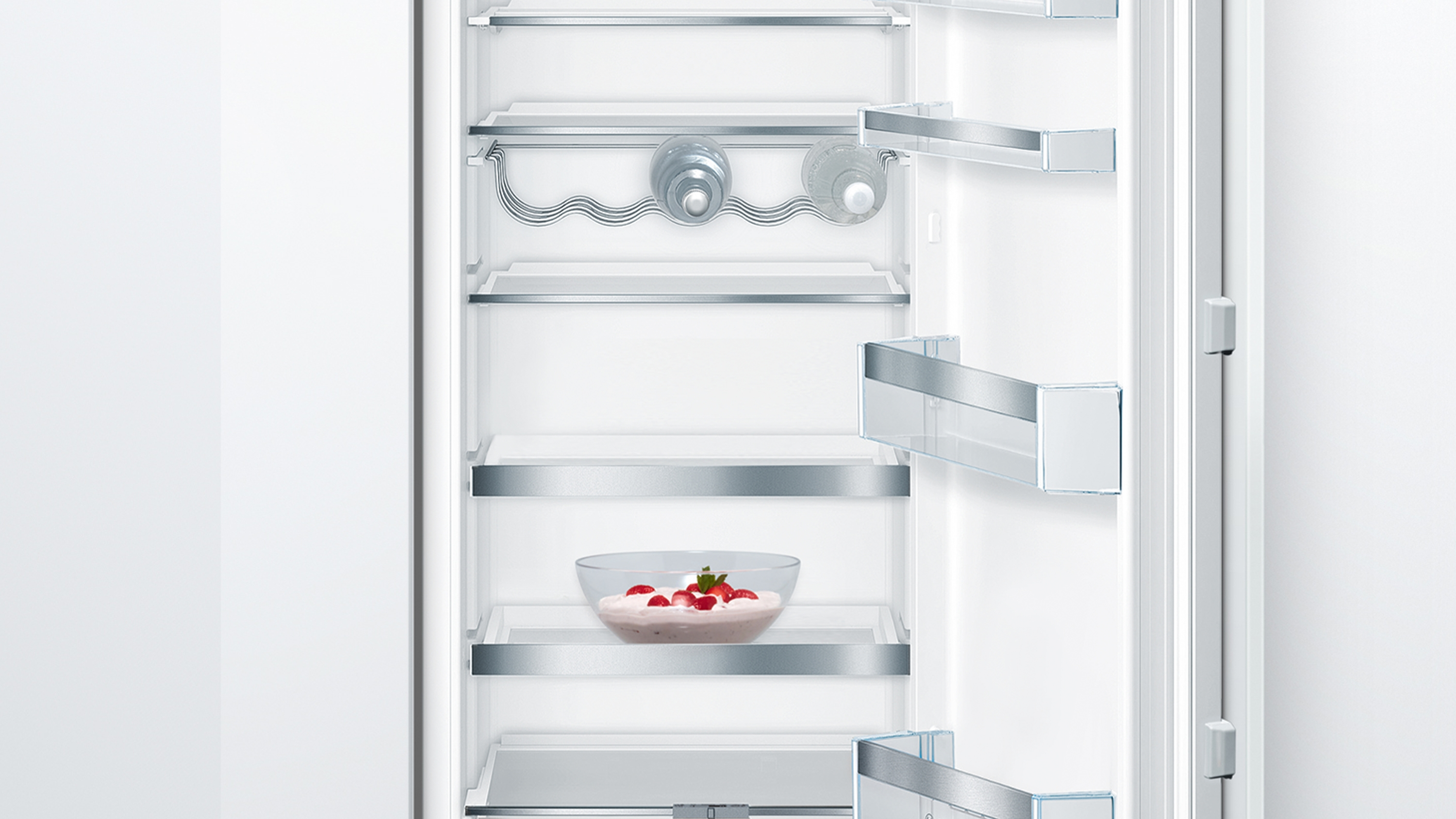 Siemens Kühlschrank Innenraum mit Glasböden und einer Schüssel mit roten Früchten.