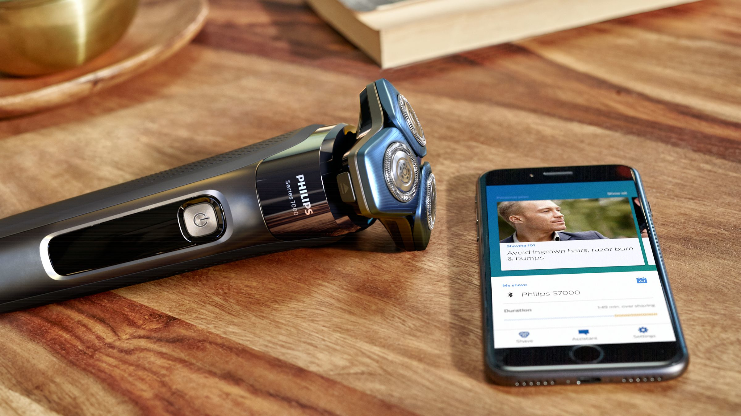 Un rasoir Philips et un smartphone affichant le guide de rasage avec des informations connexes.