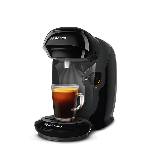 Eine schwarze Bosch Tassimo Kaffeemaschine mit einer Tasse Kaffee auf dem Sockel, schwarzer Hintergrund.