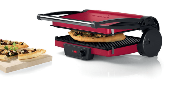 Roter Bosch Panini-Grill. Er ist geöffnet, mit einer Pizza darin, und Essen daneben.