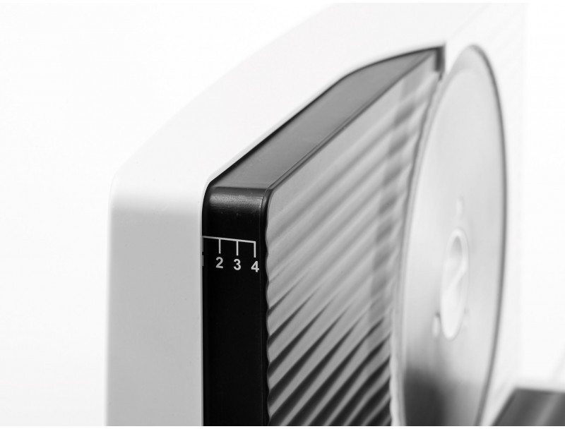 Close-up of a white and black food slicer. Numbers 1 to 4 are visible on the side. A circular blade is also seen.