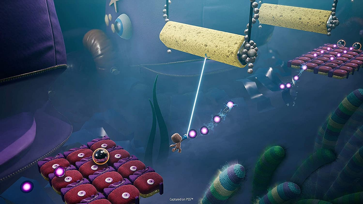 Una escena de videojuego en un entorno azul. Un personaje se balancea por plataformas. Colorido y caricaturesco.