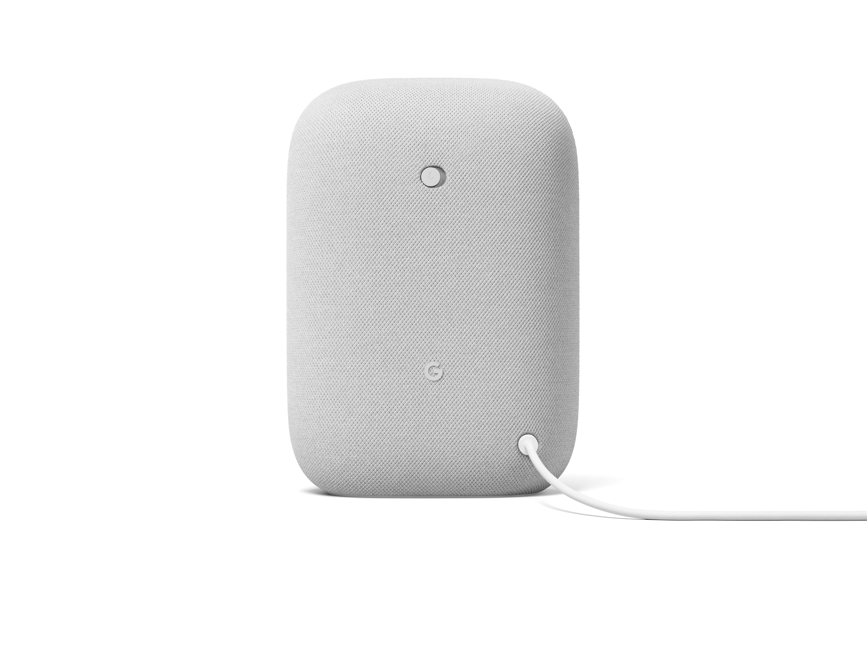 Un altavoz Google Nest Audio, blanco, con un diseño sencillo y un cable de alimentación.