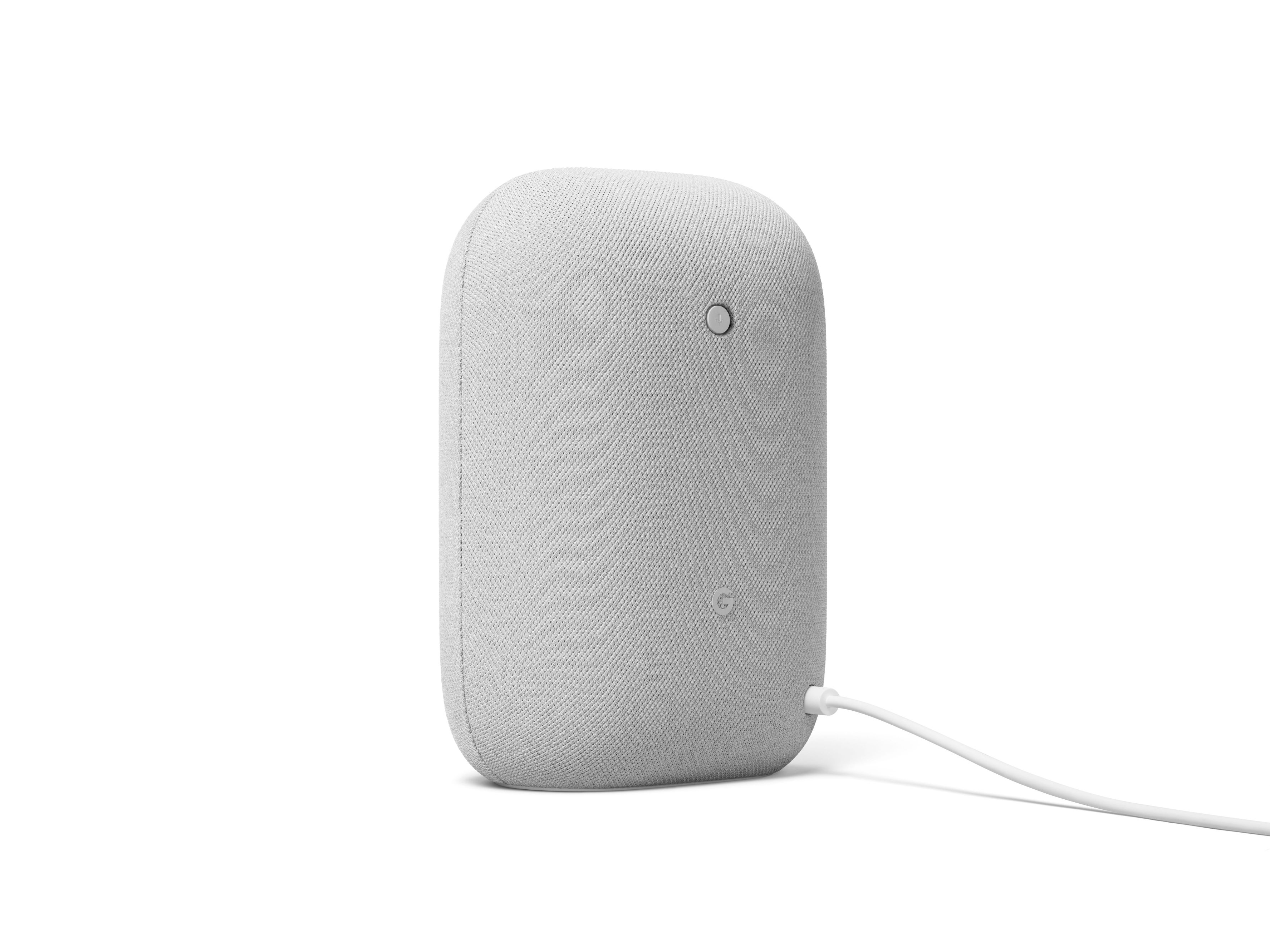 Altavoz Google Nest blanco, en posición vertical sobre superficie blanca.