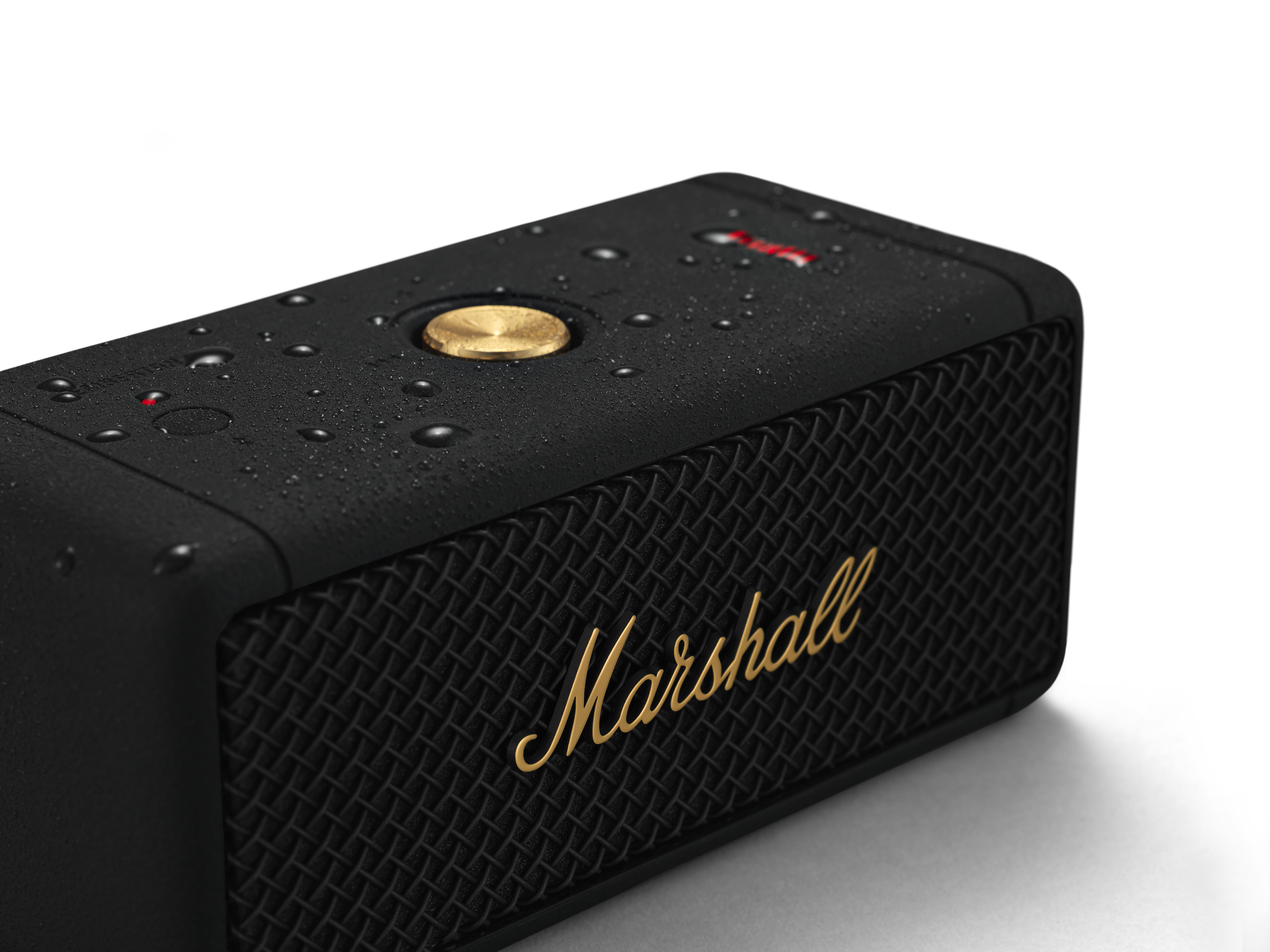 Schwarzer Marshall-Lautsprecher mit goldenem Logo, Wassertropfen sichtbar. Goldener Knopf oben. Schwarzes Mesh vorne.