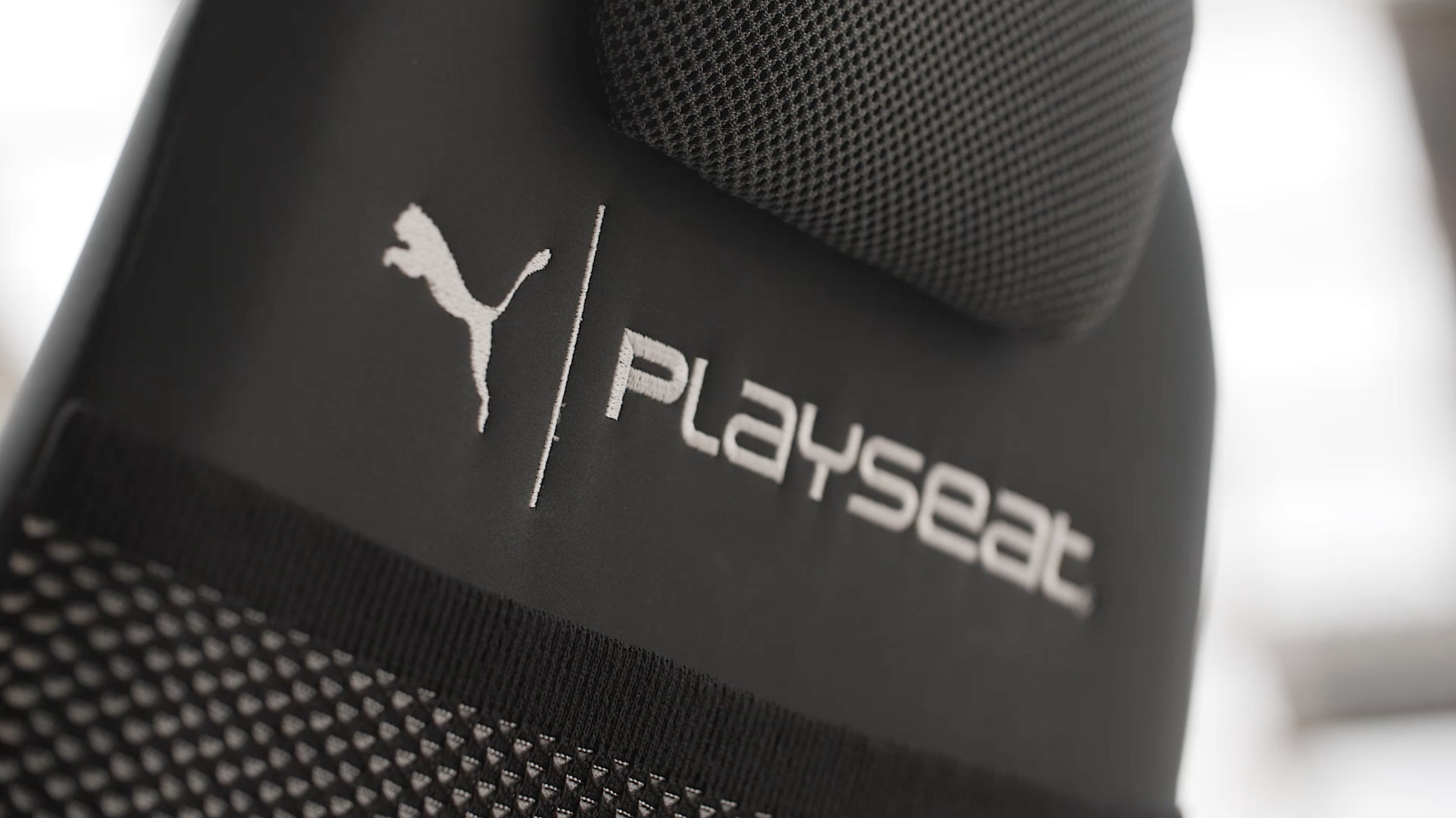 Nahaufnahme einer schwarzen Gaming-Stuhlrückseite mit dem Puma-Logo und dem Playseat-Text darauf.