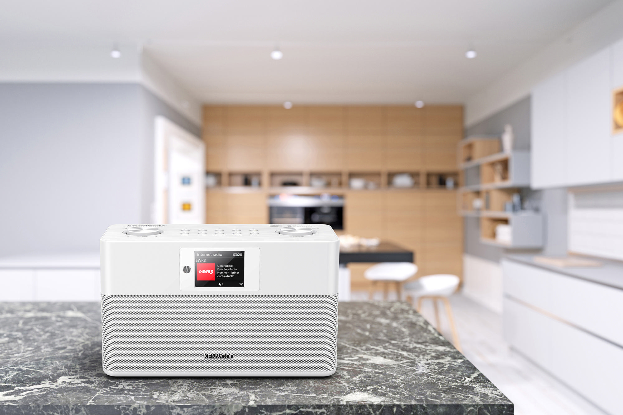 Weißes Kenwood-Radio auf einer Marmorarbeitsplatte. Küche im Hintergrund. Das Radio hat einen Bildschirm.