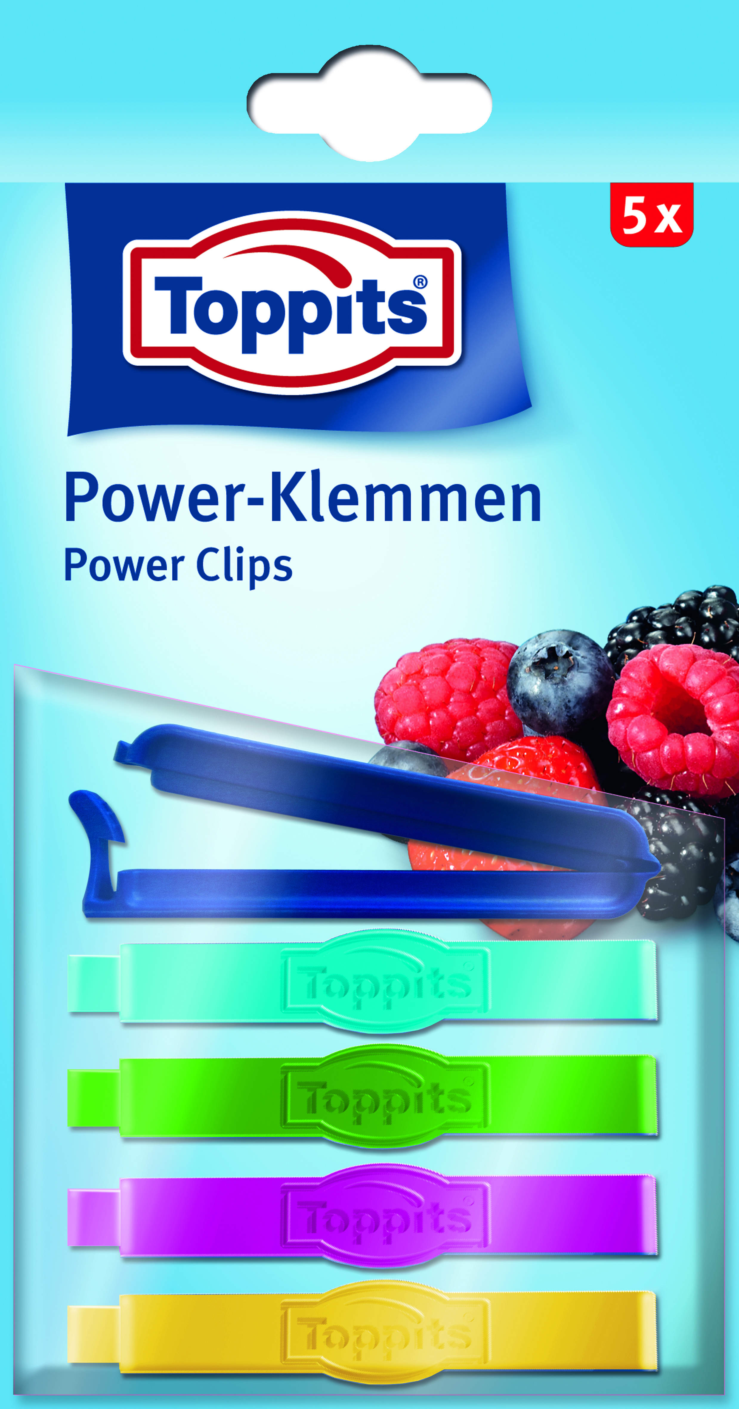 Eine Packung mit fünf bunten Toppits Power Clips. Beeren sind im Hintergrund.