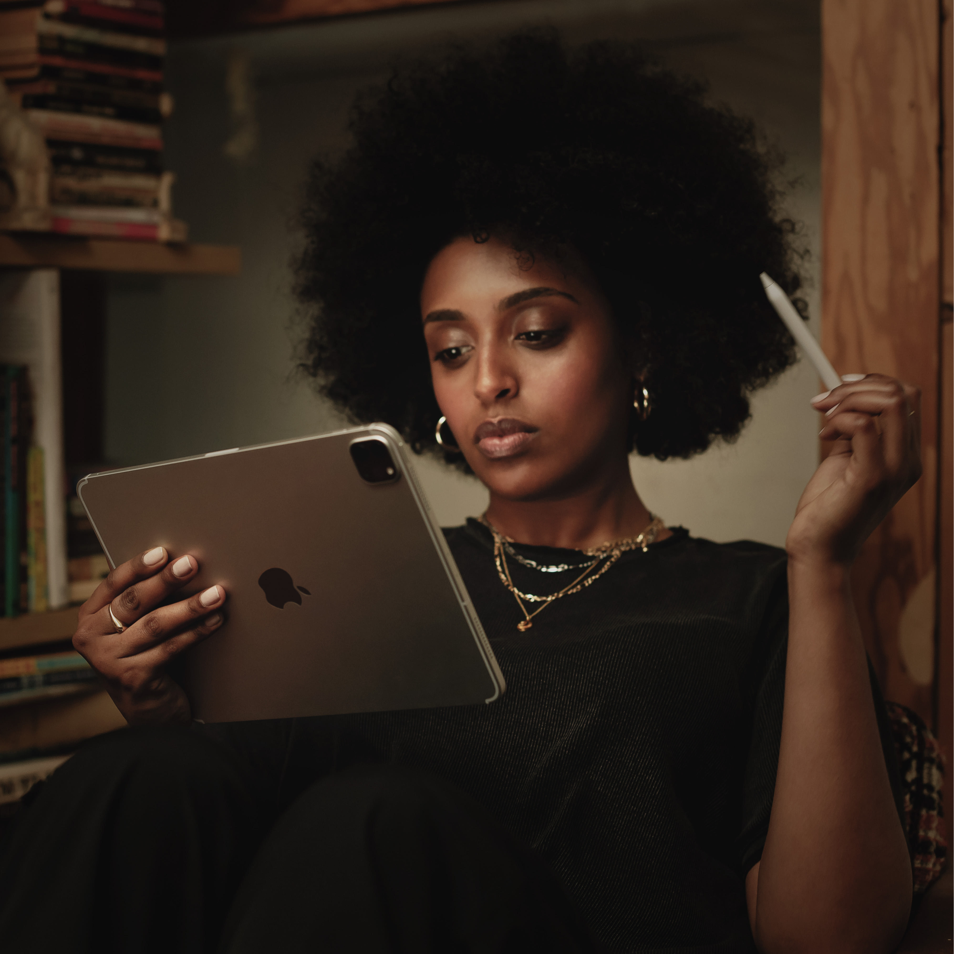 Frau mit Tablet und Stift, sitzt in einem Raum.