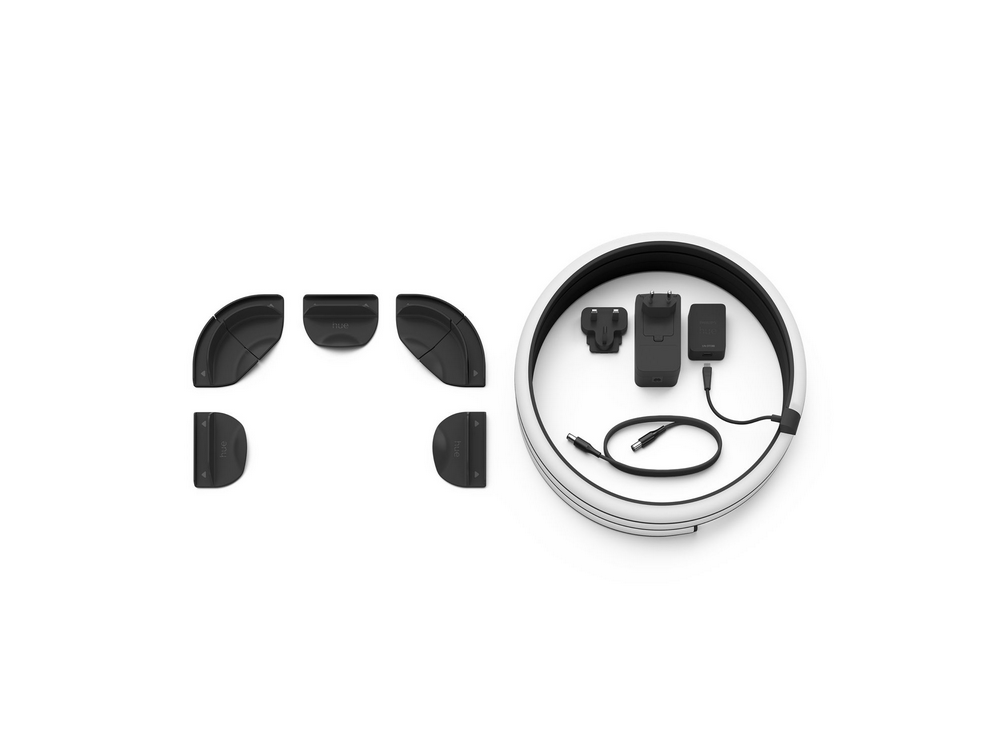 Un kit de luz circular con accesorios: esquinas, una unidad de carga y un adaptador de corriente.