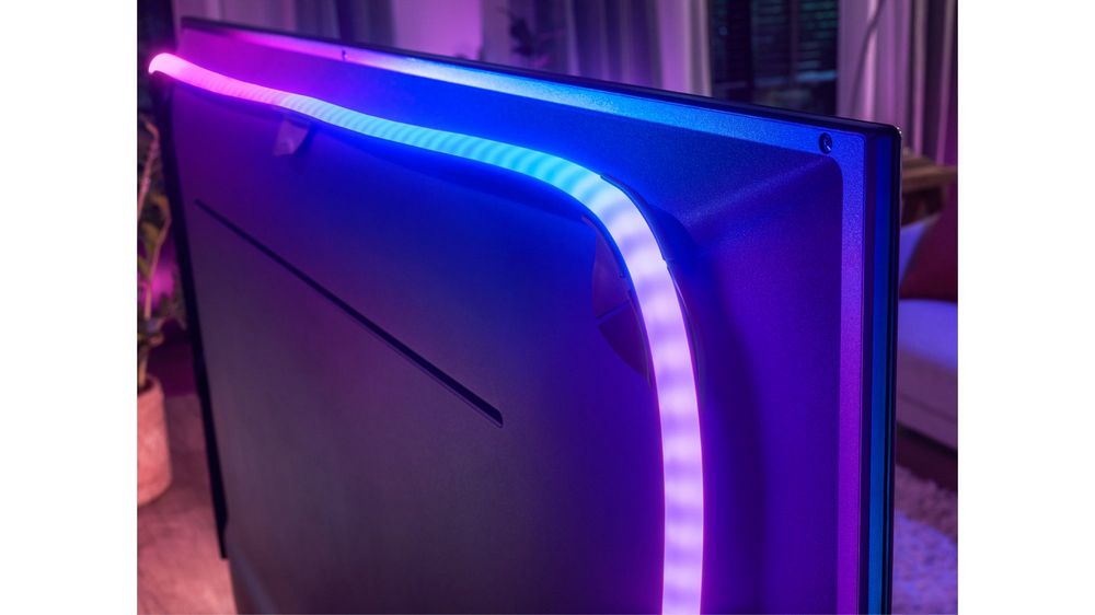 TV con tiras de luz LED adheridas al borde trasero que emiten luz azul y morada.