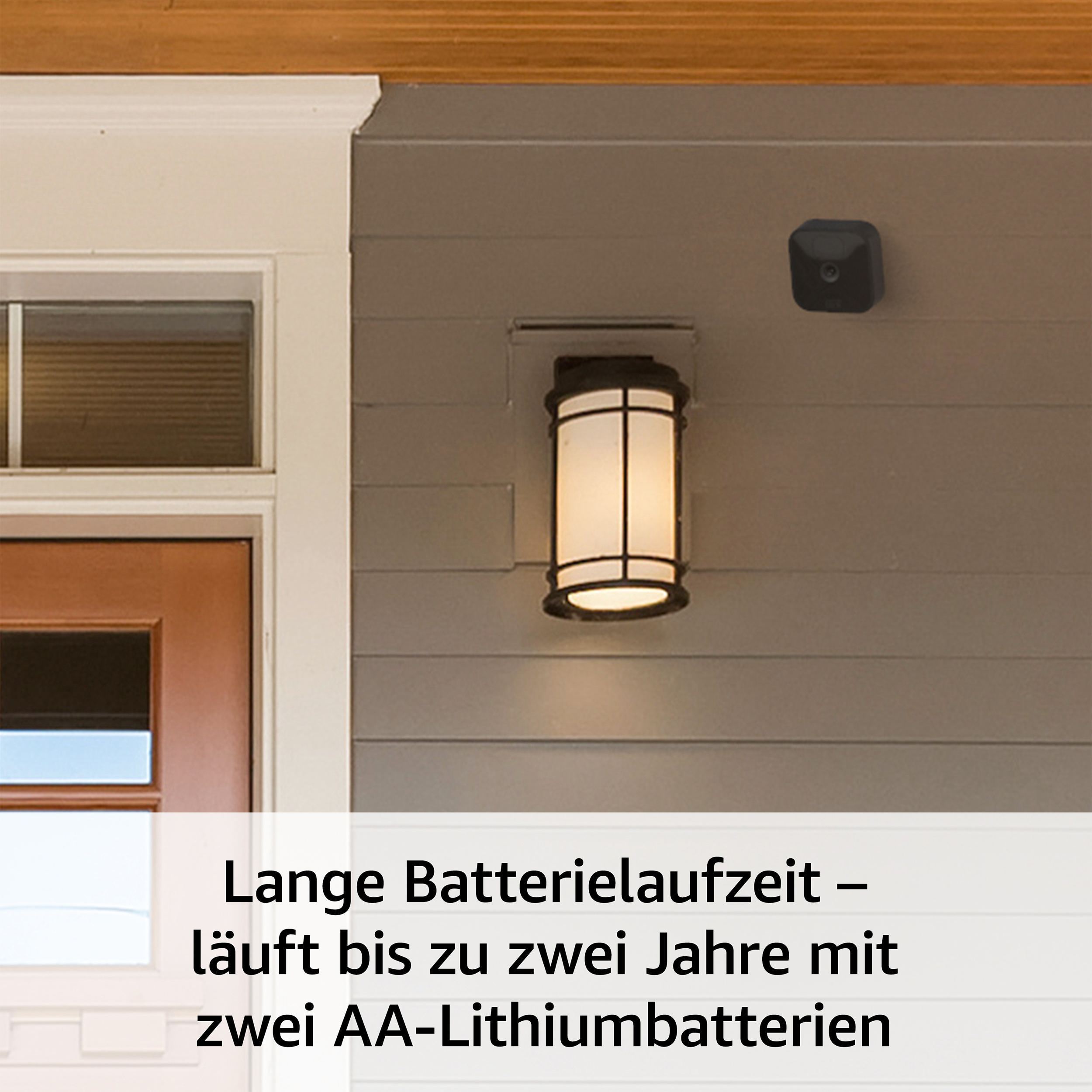 Außenaufnahme eines Hauses mit einer Überwachungskamera und einer Wandleuchte in der Nähe der Tür.