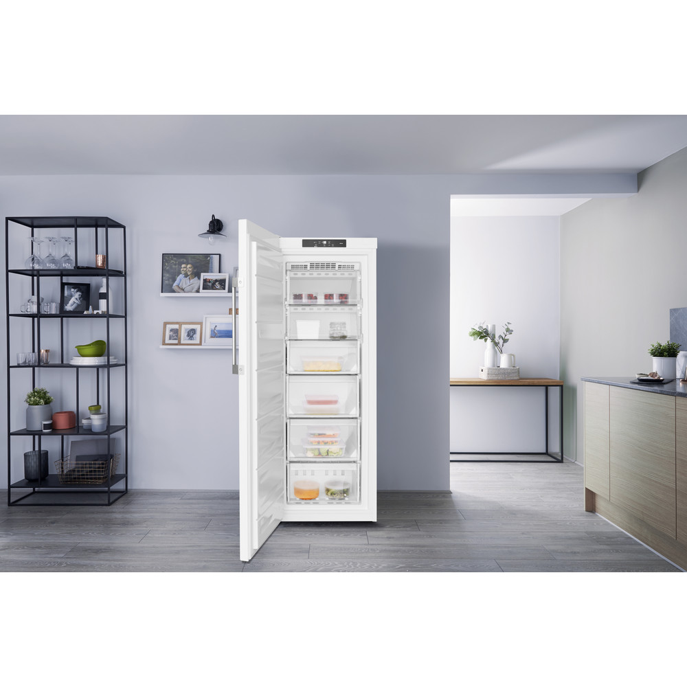 Weißer Kühlschrank mit offener Tür, die Schubladen voller Essen zeigt, in einer Küche.