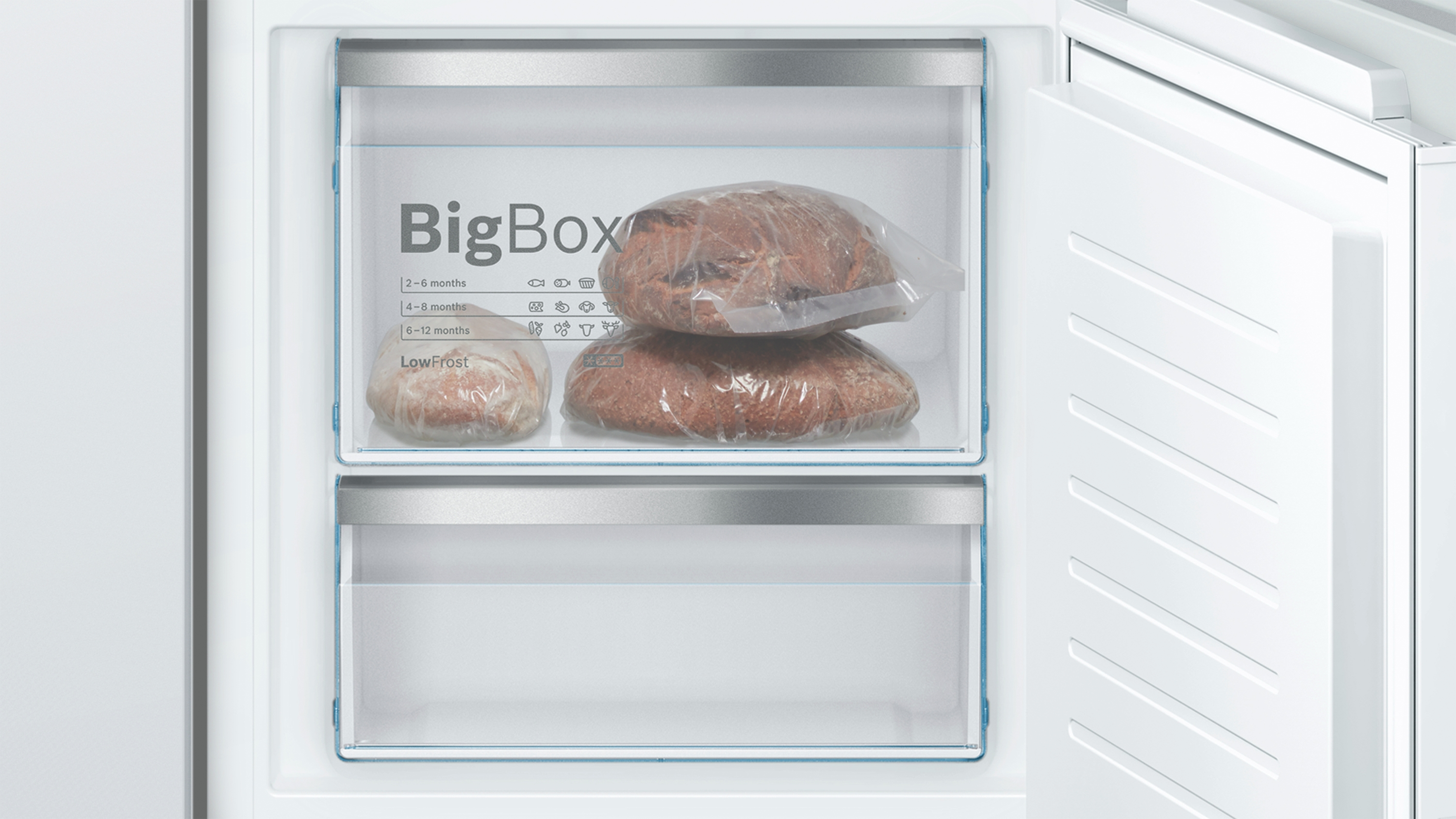 Gefrierschublade des Kühlschranks mit zwei Brotlaiben in Plastiktüten.