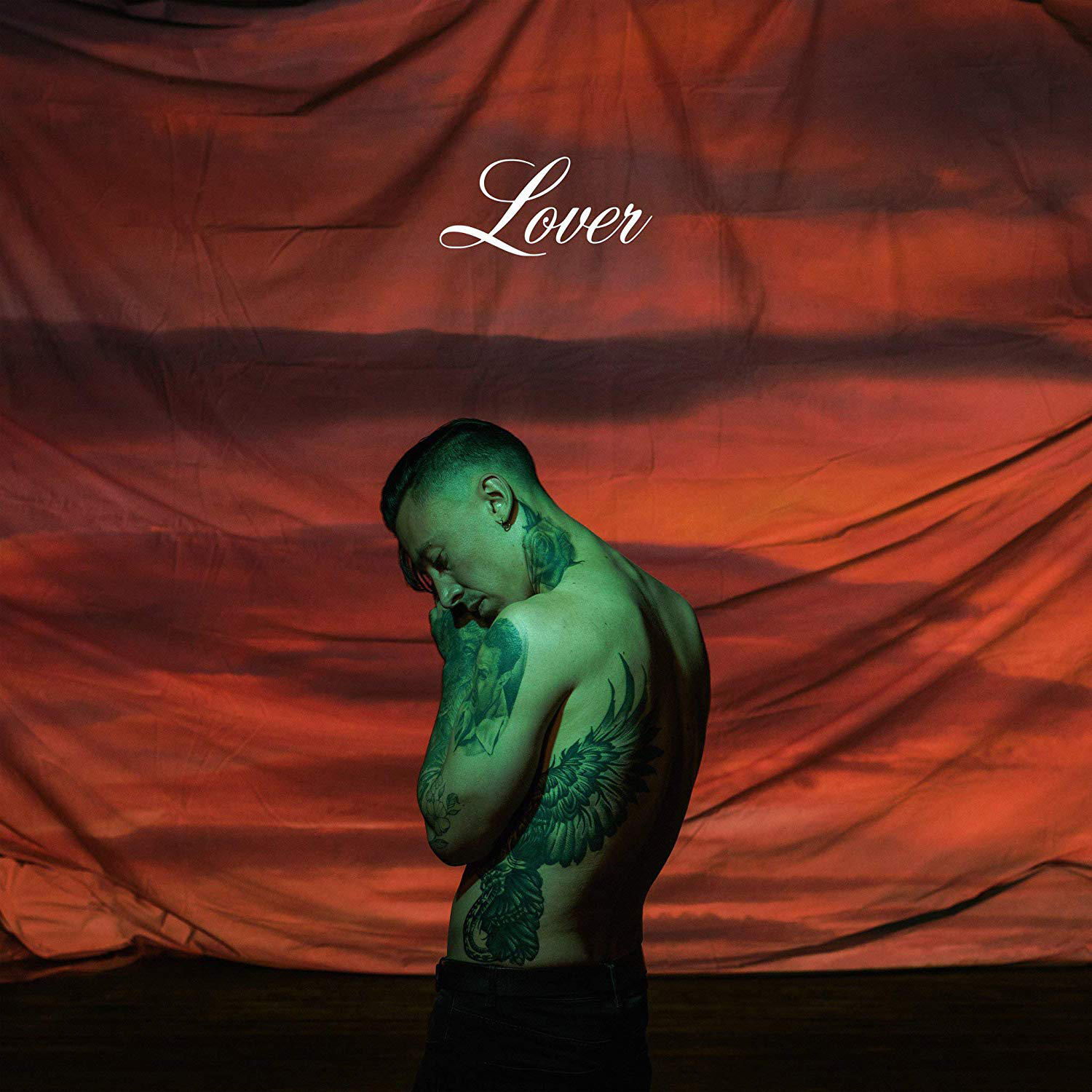 Albumcover: Mann, ohne Hemd, mit Tattoos, gesenkter Kopf, vor einem rot-orangen Hintergrund.