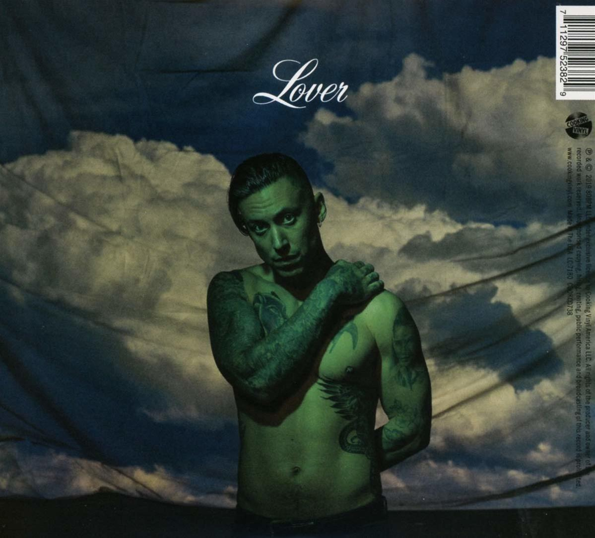 Albumcover mit tätowiertem Mann ohne Hemd, Titel 'Lover', vor bewölktem Hintergrund.