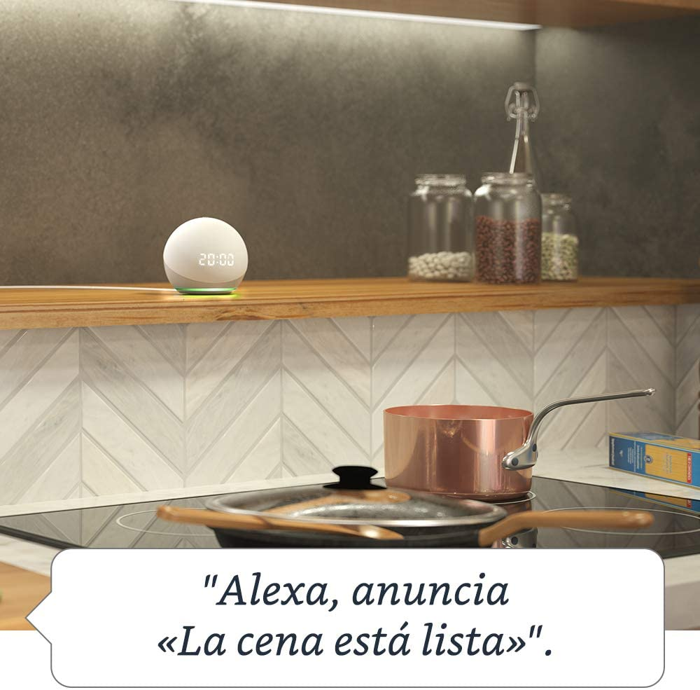 Un Amazon Echo Dot en una estantería de madera. Burbuja de texto dice: 'Alexa, anuncia...'