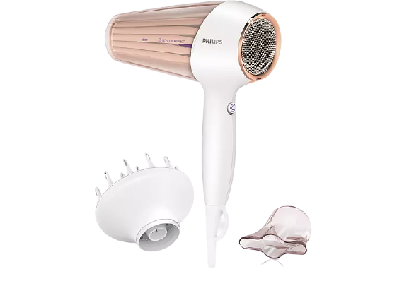 Weißer und roségoldener Haartrockner mit zwei Aufsätzen. Es ist auf schwarzem Hintergrund.