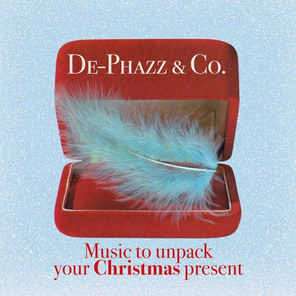 Rode doos met open deksel, blauwe veer erin. Tekst: Muziek om je kerstcadeau uit te pakken.