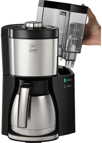 Una caffettiera Melitta Look Perfection. Una mano rimuove il serbatoio dell'acqua.