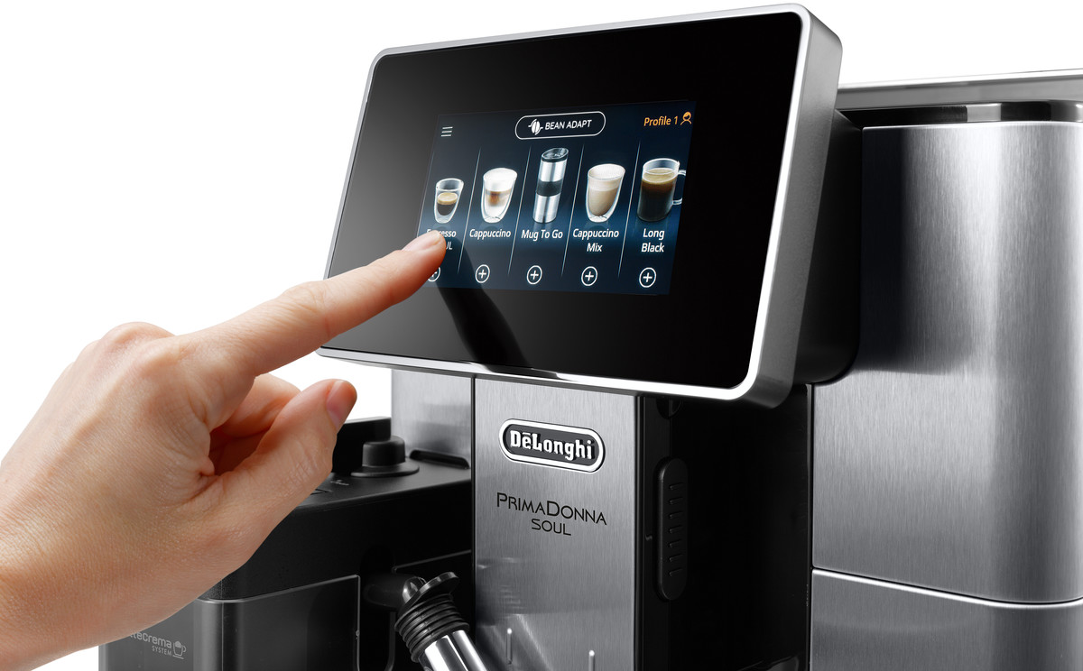 Ein Finger berührt den Bildschirm einer Delonghi Primadonna Soul Kaffeemaschine.