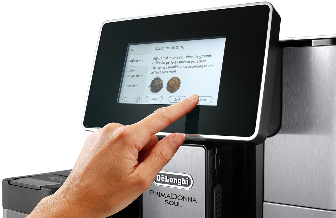 Person benutzt Touchscreen an einer Delonghi Kaffeemaschine.