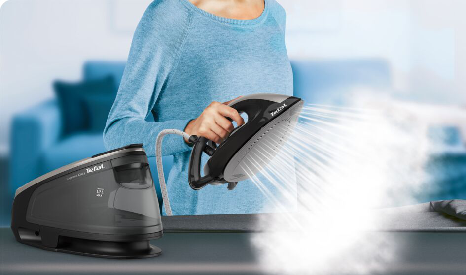 Frau bügelt mit einem Tefal Express Easy Bügeleisen. Dampf ist sichtbar. Die Basis ist links.
