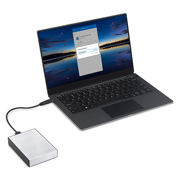 A laptop connected to a silver external hard drive, displaying a password prompt.