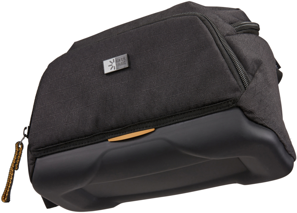 Sac photo noir avec logo argenté et tirette de fermeture éclair jaune, avec surface texturée.