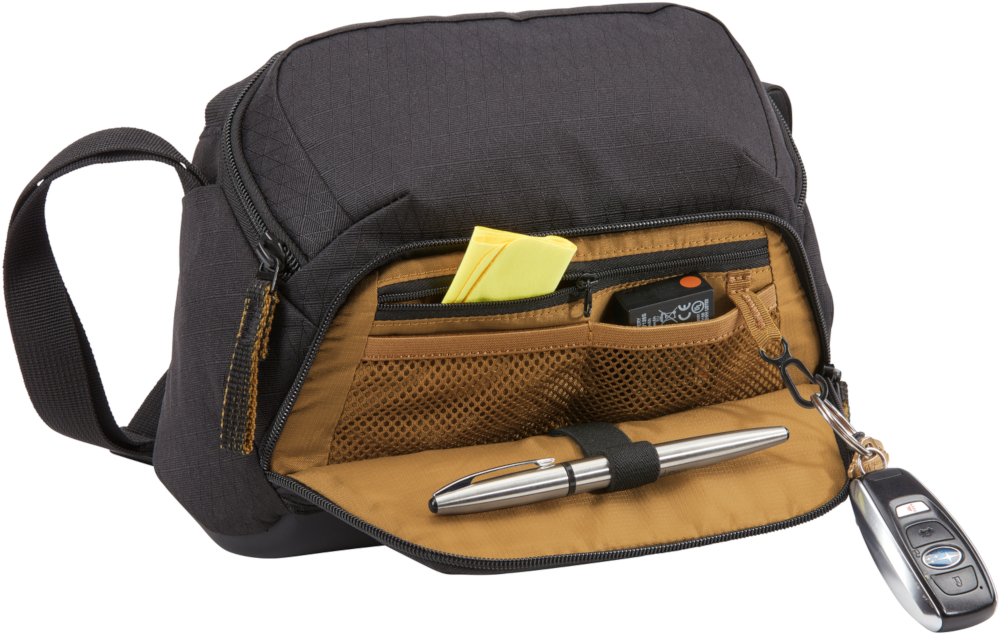 Sac noir ouvert avec stylo, bloc-notes et clé de voiture.