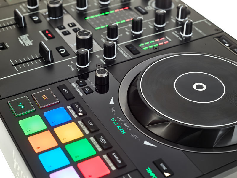 Nahaufnahme eines schwarzen DJ-Mixers mit Bedienelementen, Knöpfen und einem Jog-Rad, isoliert auf weißem Hintergrund.