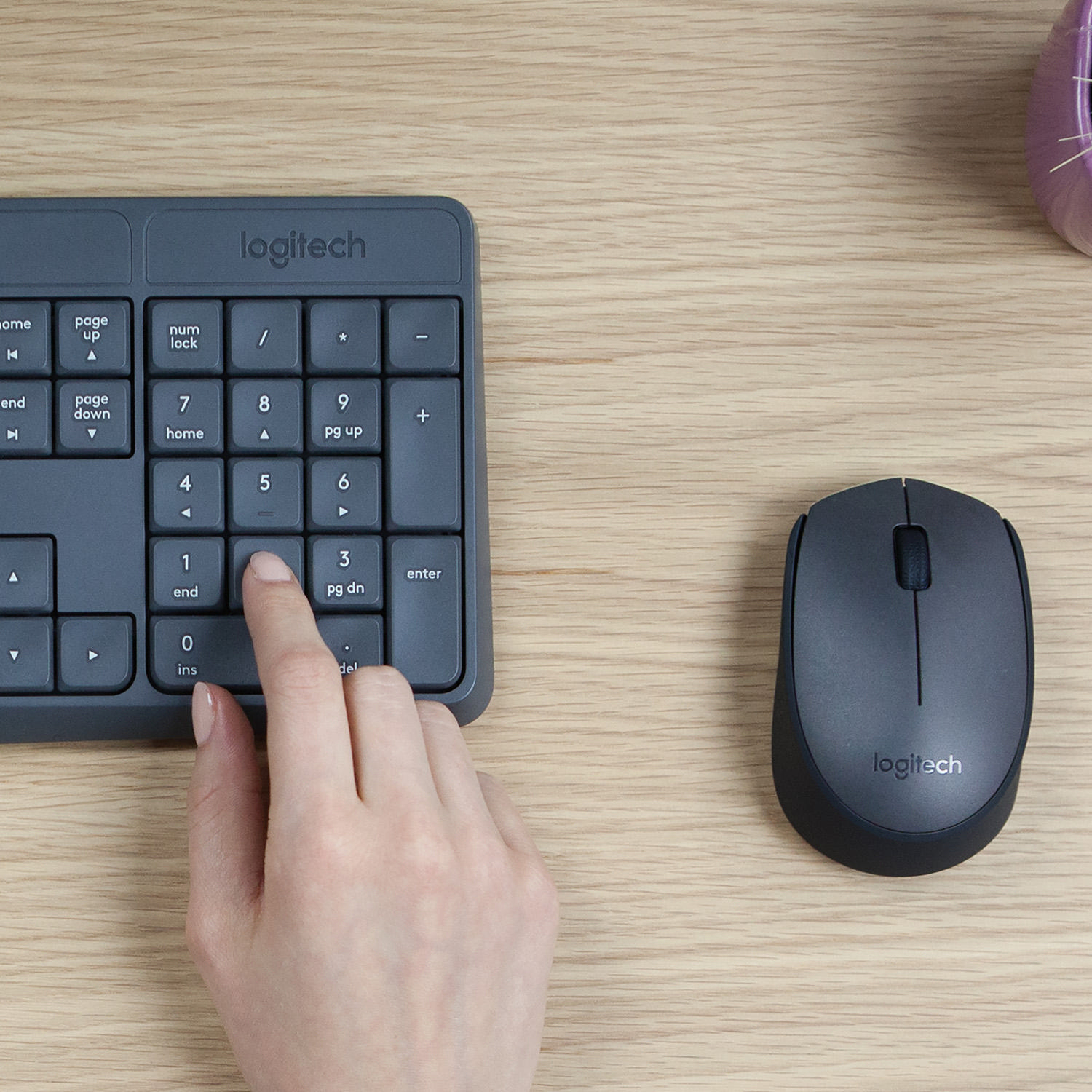 Hand drückt '1' auf Logitech-Tastatur. Maus daneben.