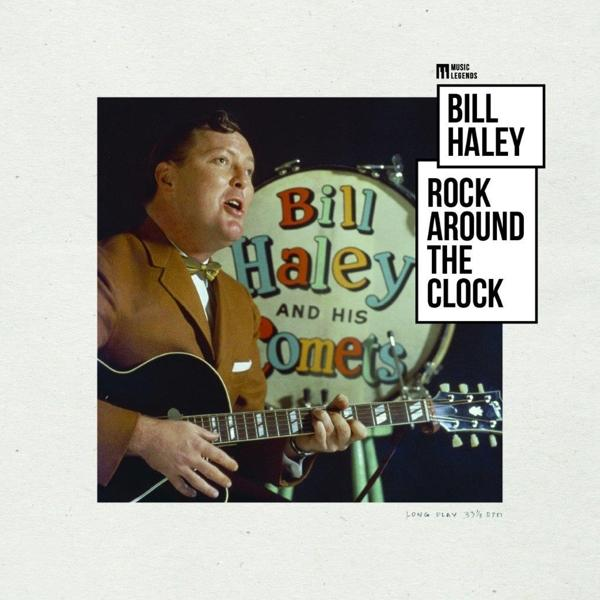 Bill Haley speelt gitaar op het podium, met zijn band en een 'Rock Around the Clock' drum.