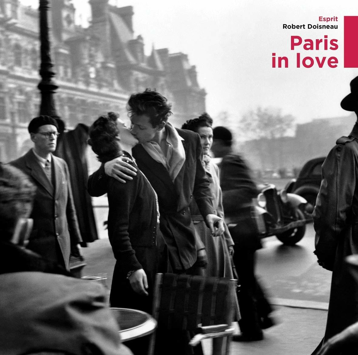Schwarz-Weiß-Foto eines sich küssenden Paares, umgeben von Menschen. Titel: Paris in Love.