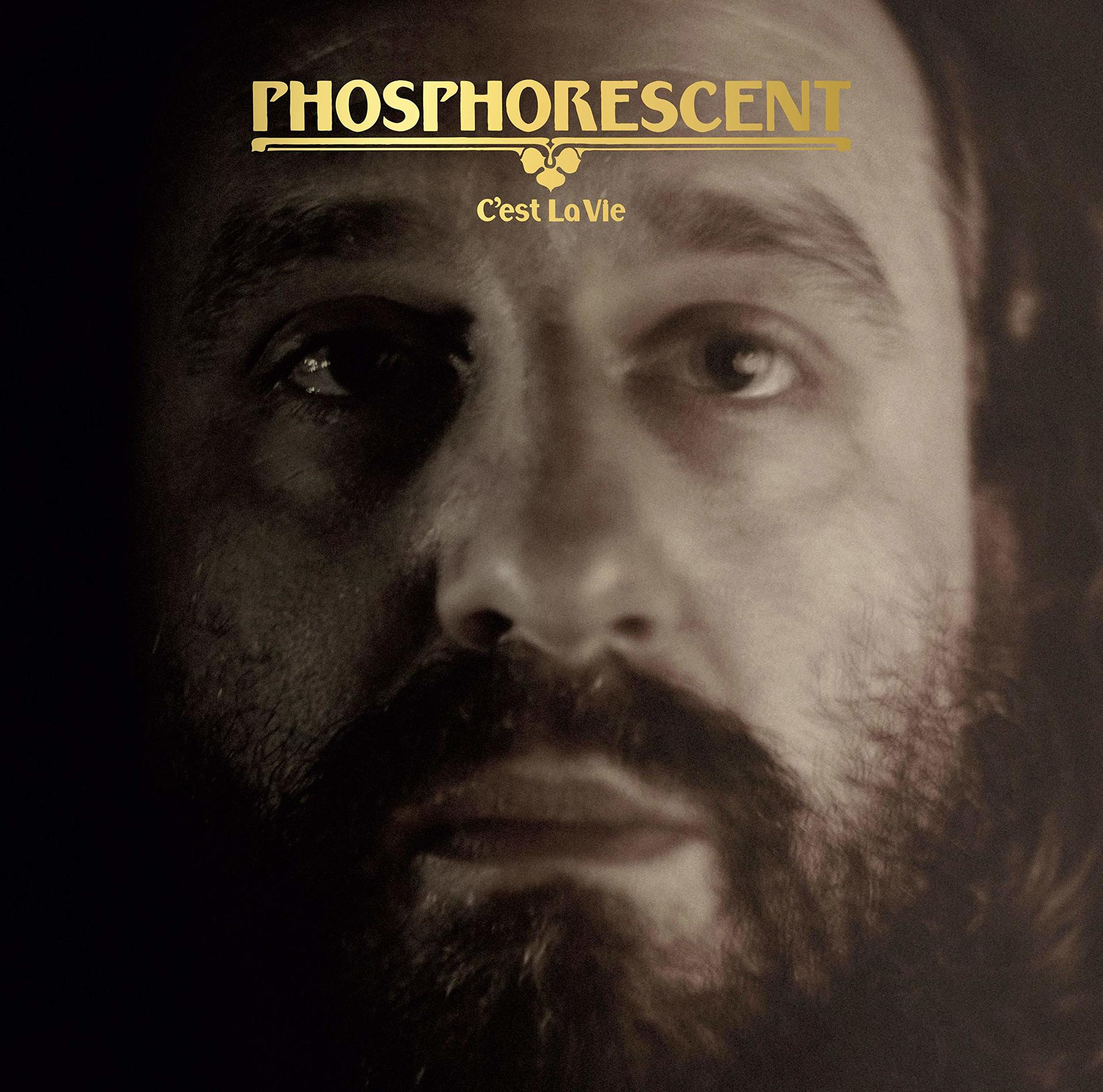 Nahaufnahme eines Mannes, Text 'Phosphorescent C'est La Vie' oben.